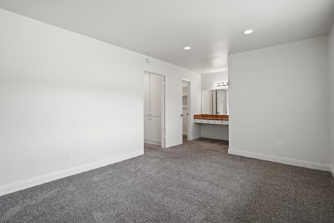 A large empty room with a carpeted floor and white walls.