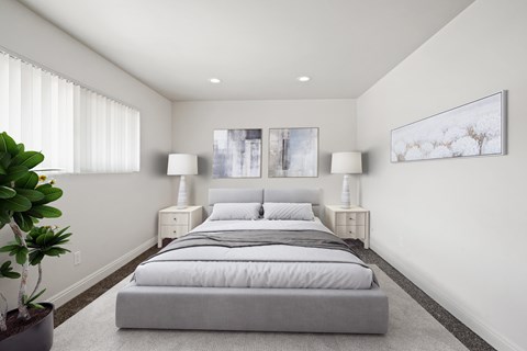 A bedroom with a large bed and two lamps.
