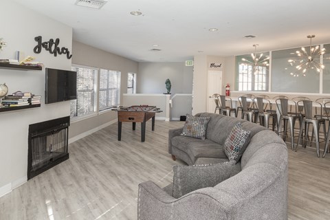 A living room with a grey couch and a fireplace.