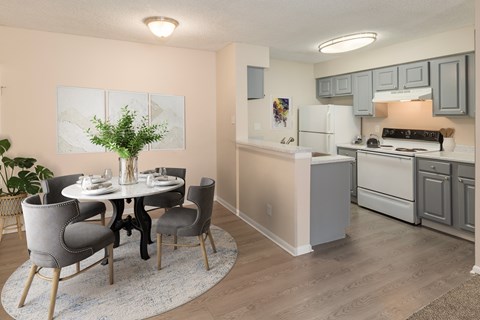 A dining room with a white table and grey chairs.