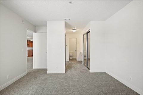 A white room with a carpeted floor and a white door.