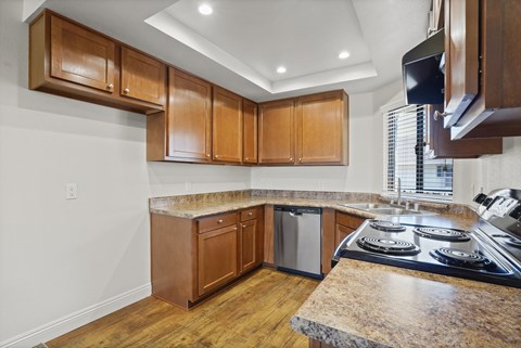 A kitchen with wooden cabinets and a granite countertop.