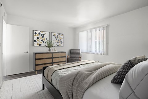 A bedroom with a bed, nightstand, and two paintings on the wall.
