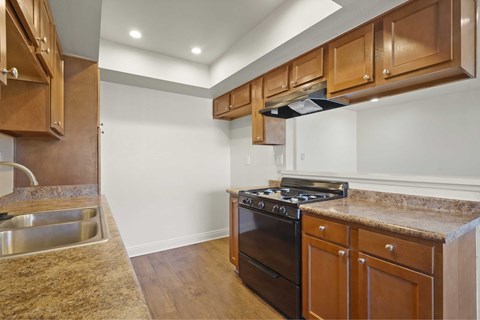 A kitchen with wooden cabinets and a black stove top oven.