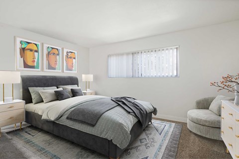 A bedroom with a bed, chair, and three framed pictures on the wall.