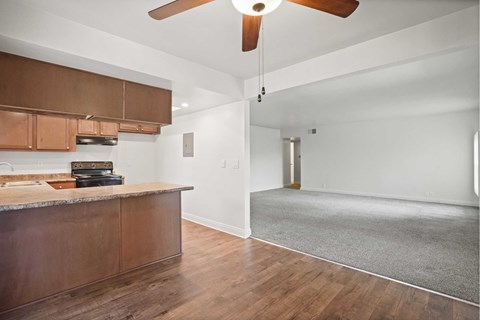 A kitchen with wooden cabinets and a ceiling fan.
