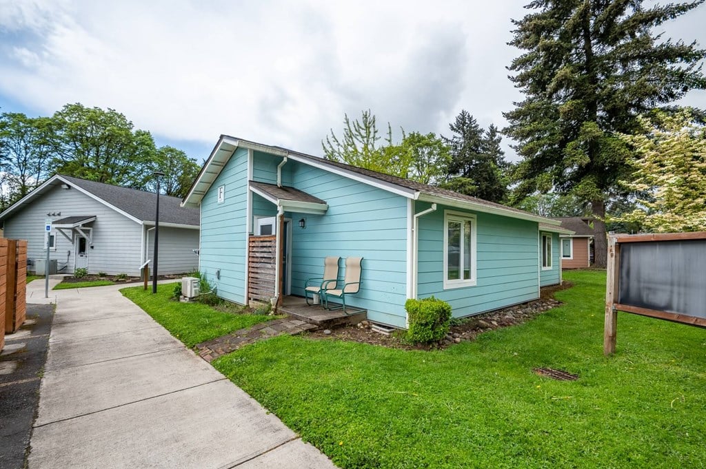 a blue house with a sidewalk in front of it