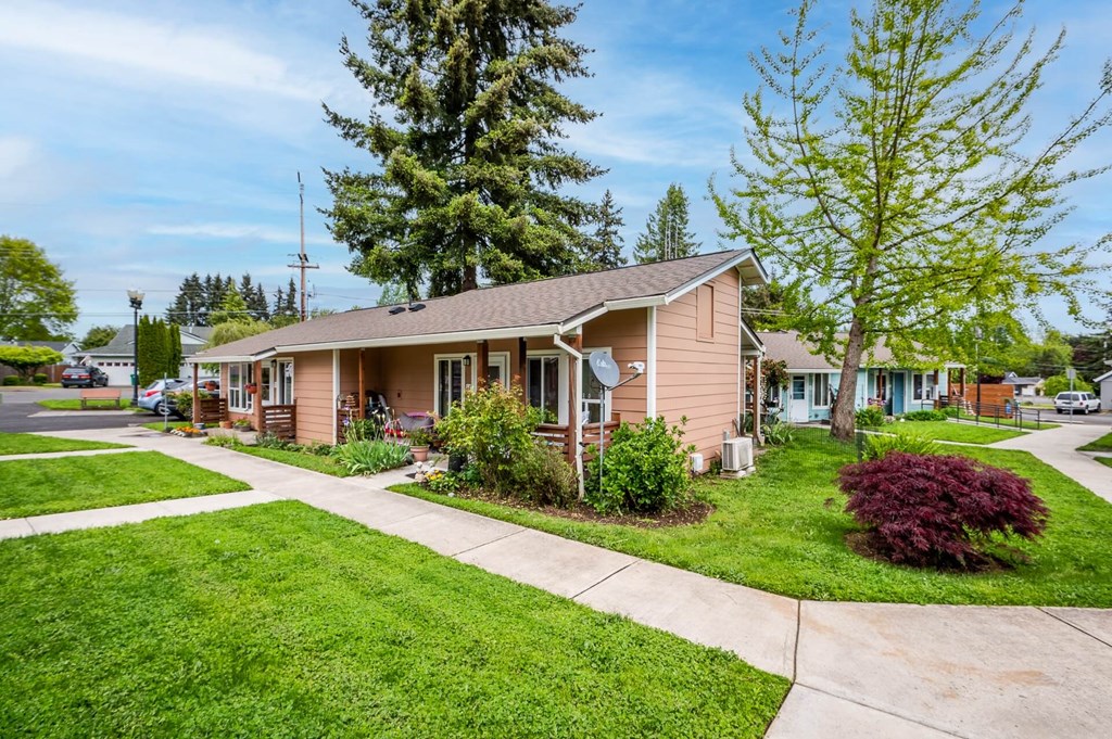 a small pink house with a sidewalk in front of it