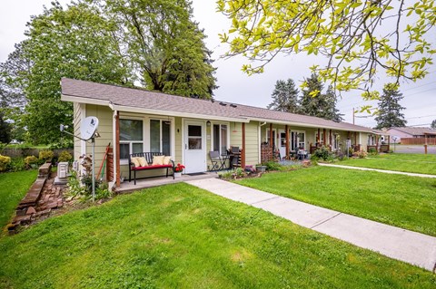 the front of a house with a yard and a sidewalk