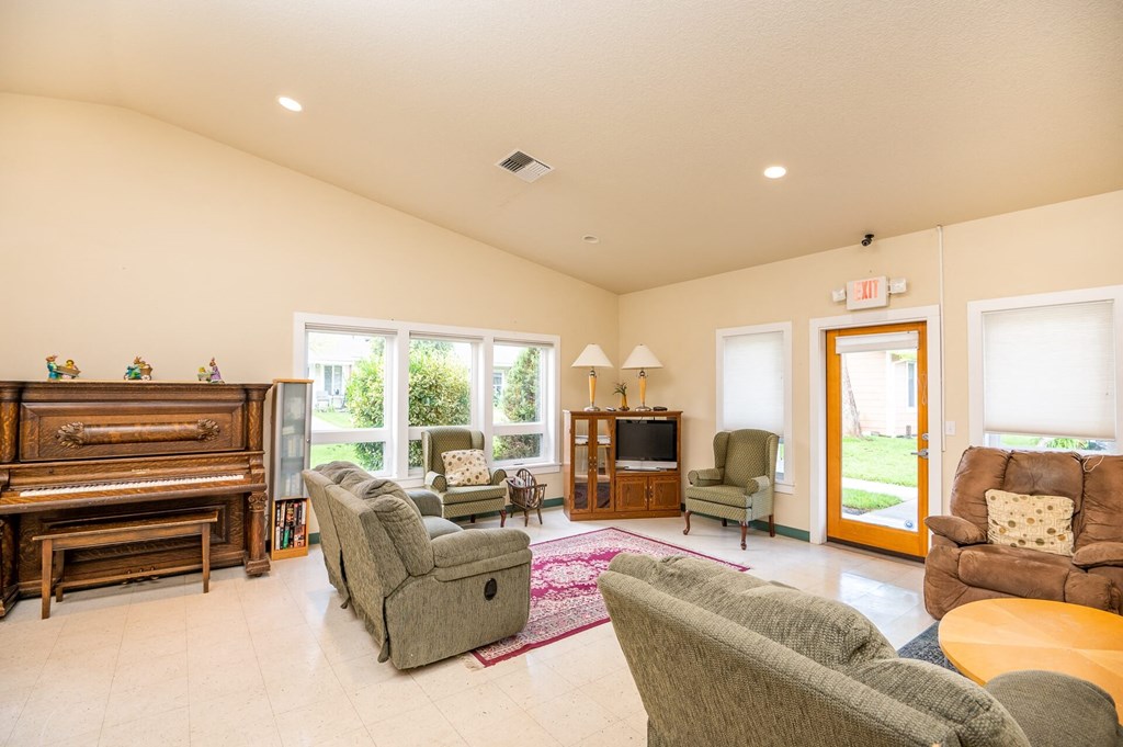 a living room with furniture and a piano