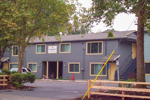 A grey building with a yellow pole in front.