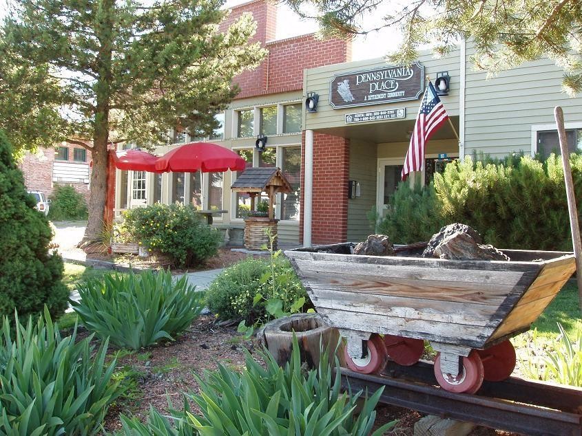 a boat sitting in a garden in front of a building