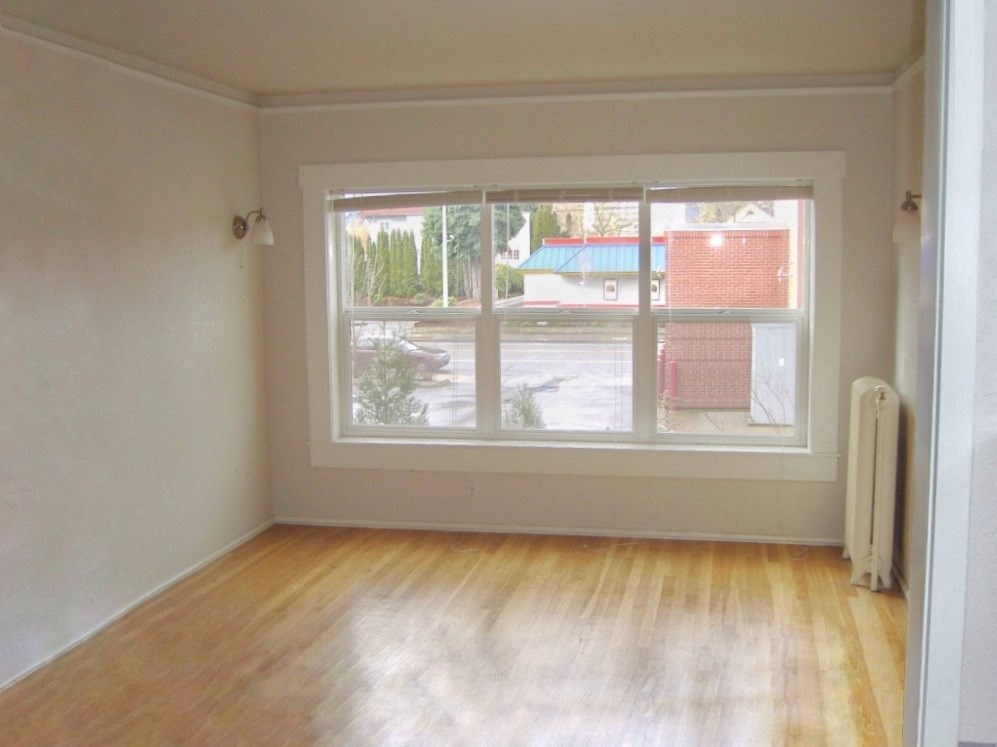 an empty room with wooden floors and white walls