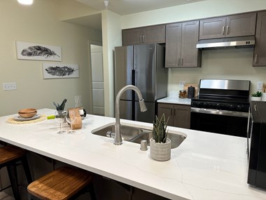a kitchen with gray cabinets and a white counter top