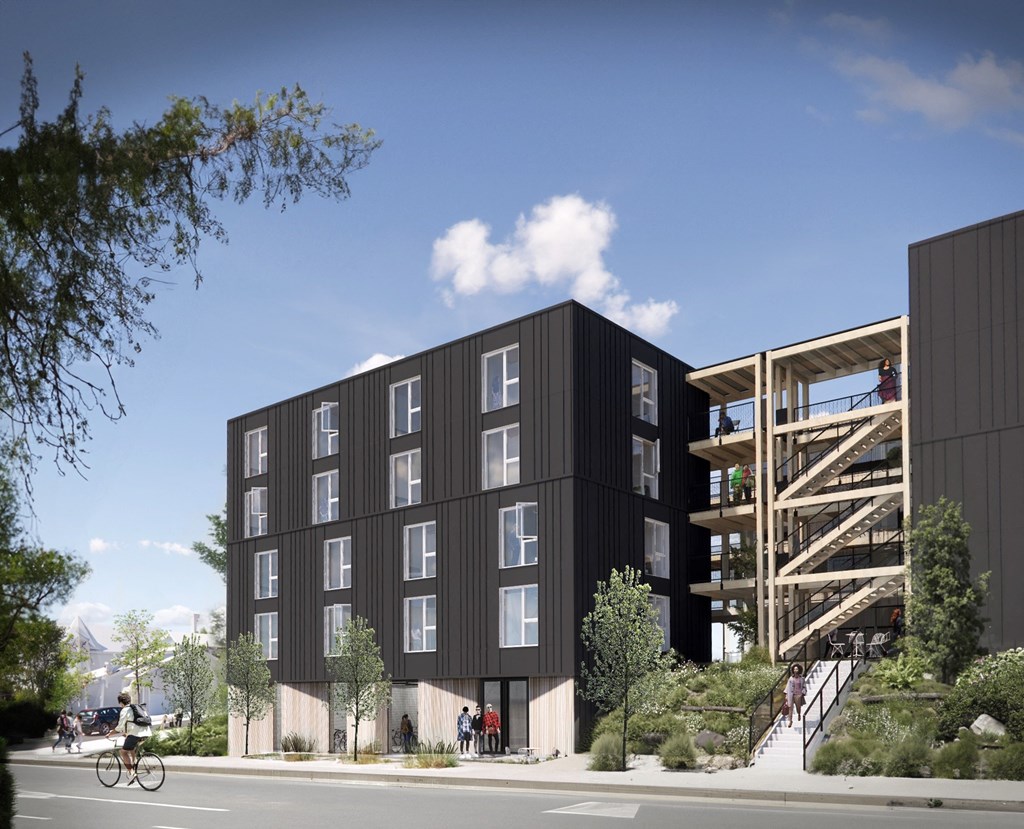 A modern black building with a bicycle parked in front.