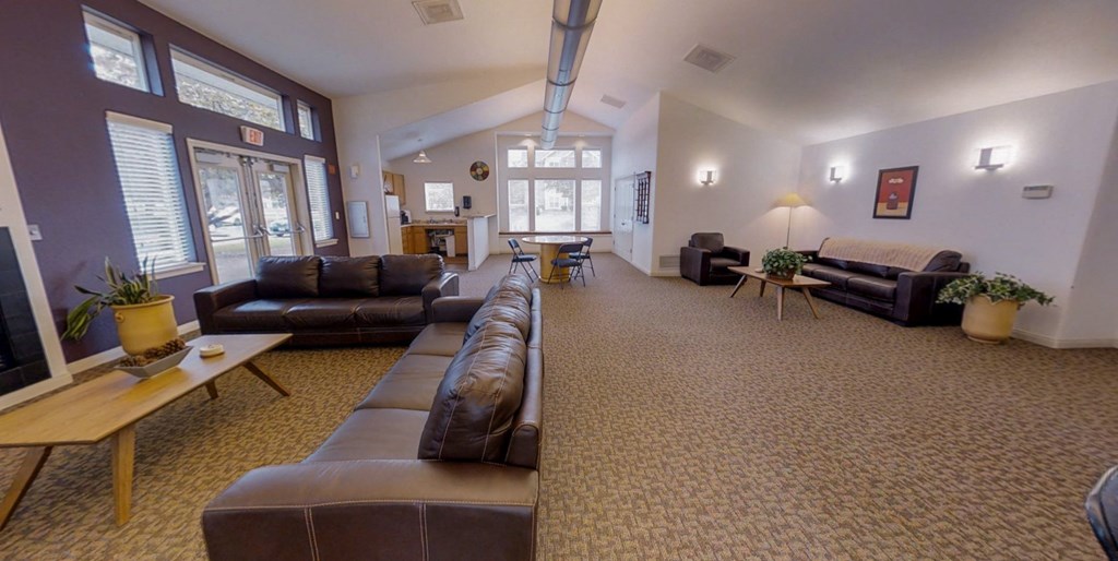 a large living room with leather couches and chairs