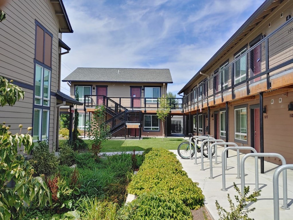 a courtyard with a patio and chairs in front of a building