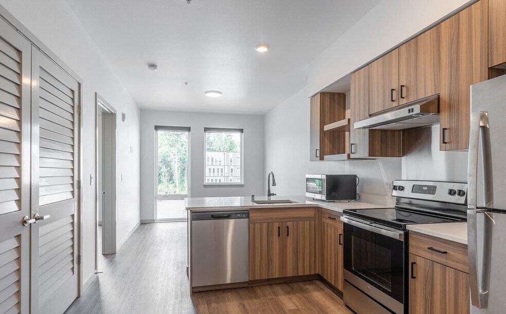 a kitchen with a stove top oven next to a refrigerator