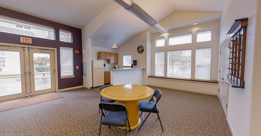 a dining room with a table and chairs and a kitchen