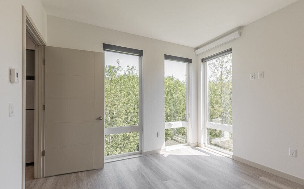 an empty room with three windows and a door