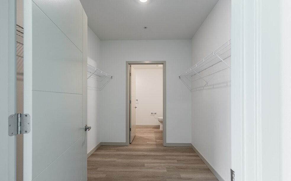 a hallway with white walls and a wooden floor