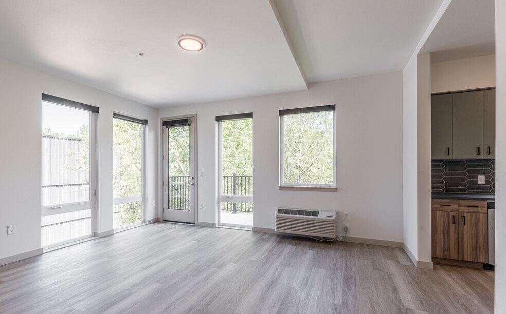 an empty living room with a door to a balcony