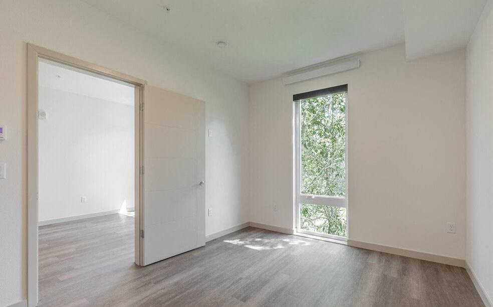 an empty room with a large window and a door