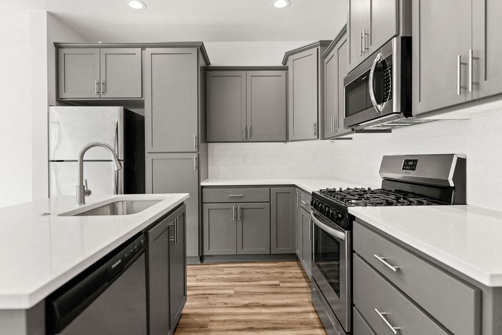 a kitchen with stainless steel appliances and white counter tops
