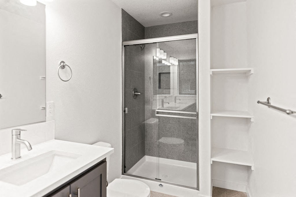 a bathroom with a shower and a sink and a mirror