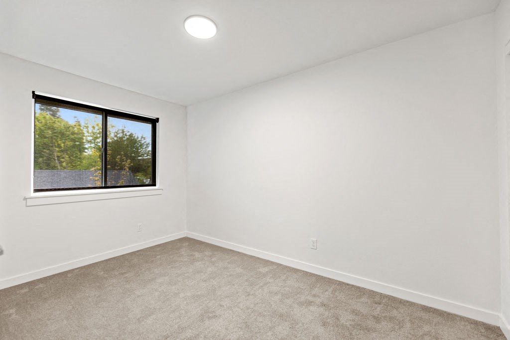 an empty room with a window and carpet