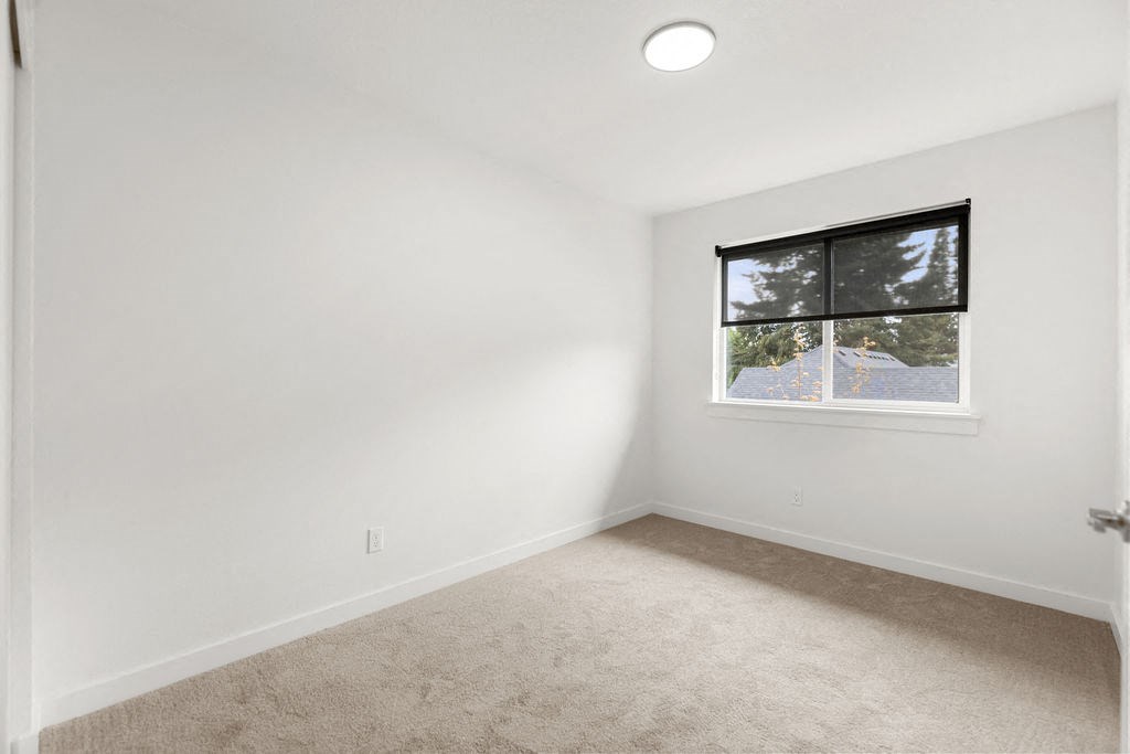 a white room with a window and carpet