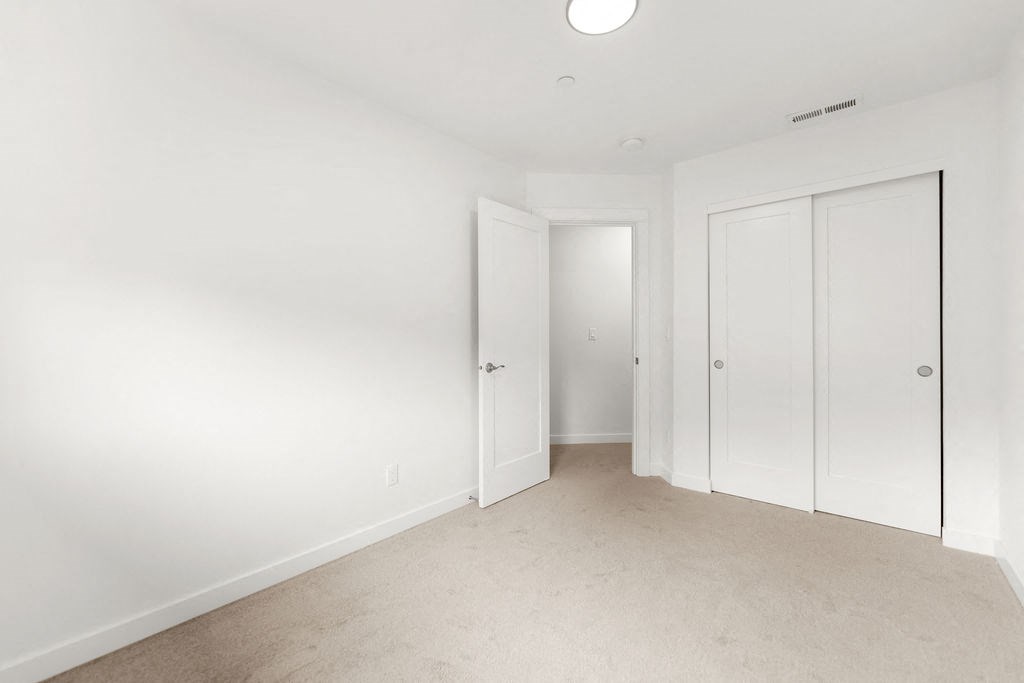 a bedroom with two closets and a carpeted floor