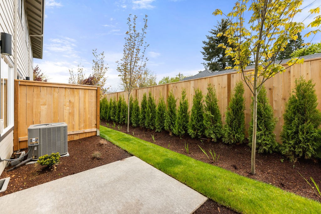 a yard with a wooden fence and a grass