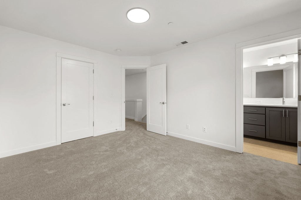 a bedroom with a closet and a bathroom with a mirror