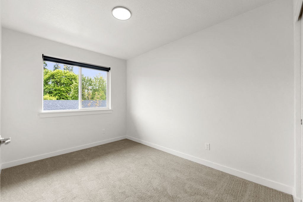 an empty room with a window and carpet