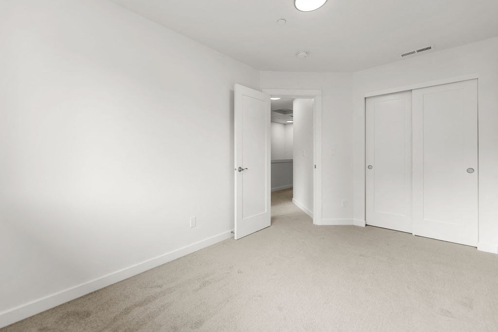 a bedroom with white walls and white doors and carpet