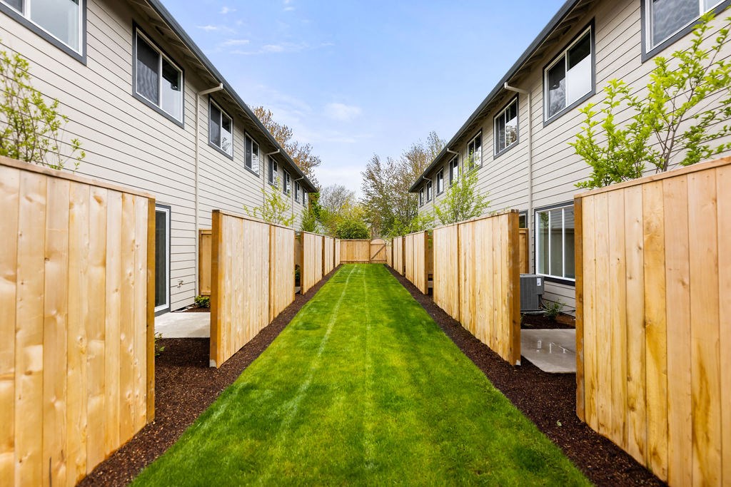 a yard with a wooden fence and grass