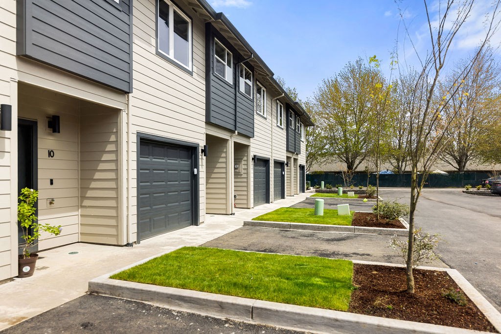 a row of town homes with garages and grass