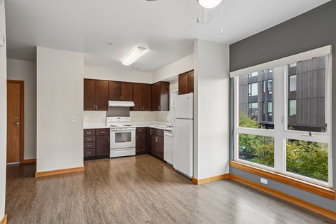 A kitchen with white appliances and wooden cabinets.