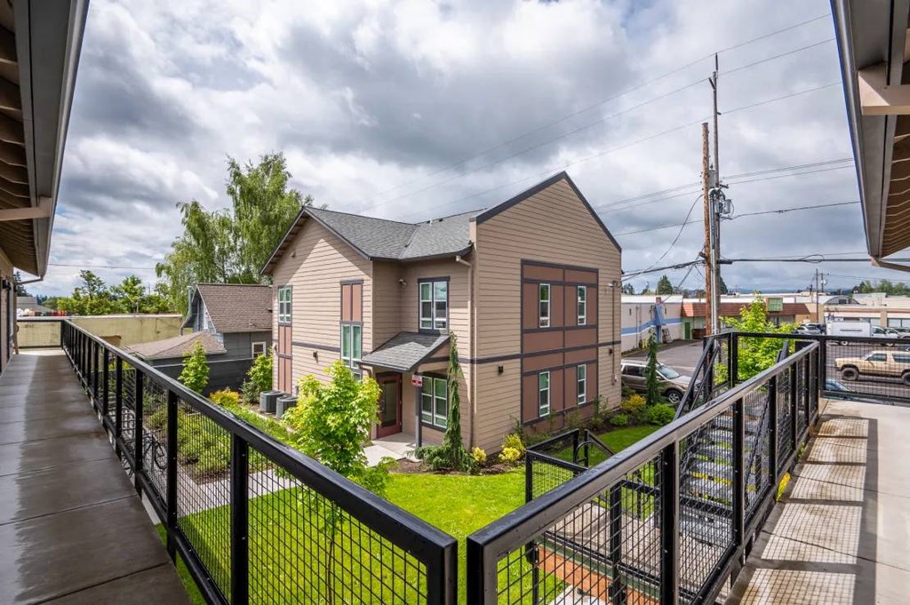 the view of a house from a balcony with a black fence