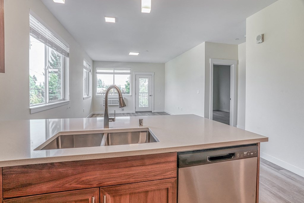 a kitchen with white walls and a wooden island with a stainless steel sink