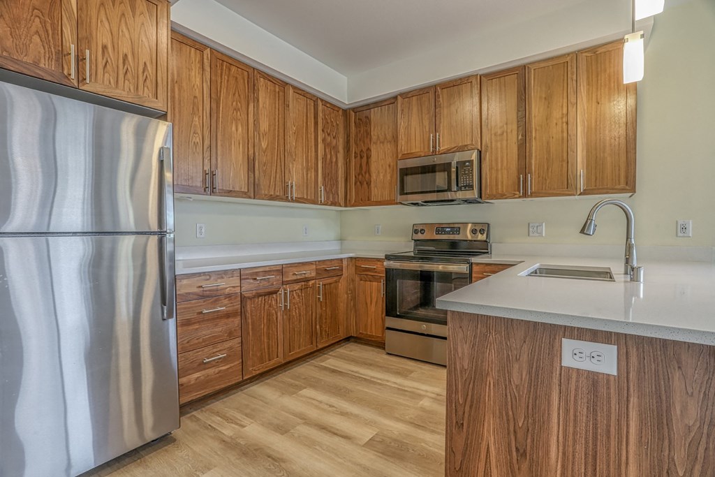 a kitchen with wooden cabinets and stainless steel appliances