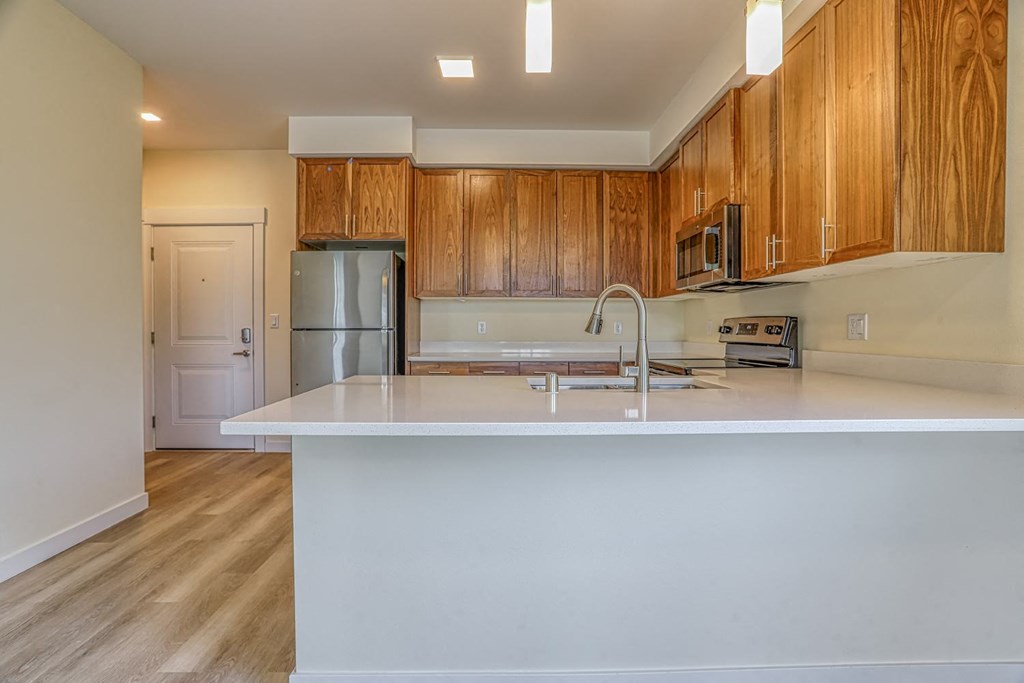 a kitchen with white countertops and wooden cabinets