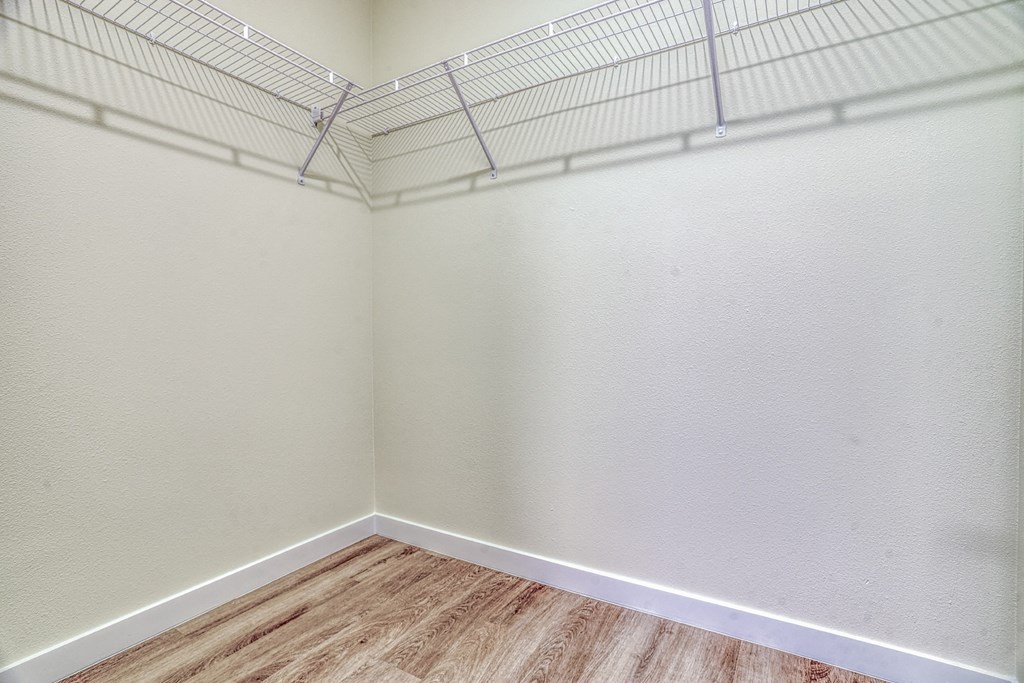 an empty room with white walls and a wooden floor