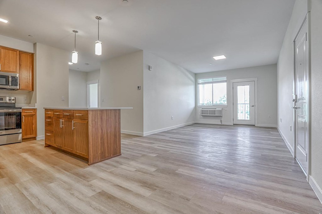 a kitchen and living room with a wooden floor