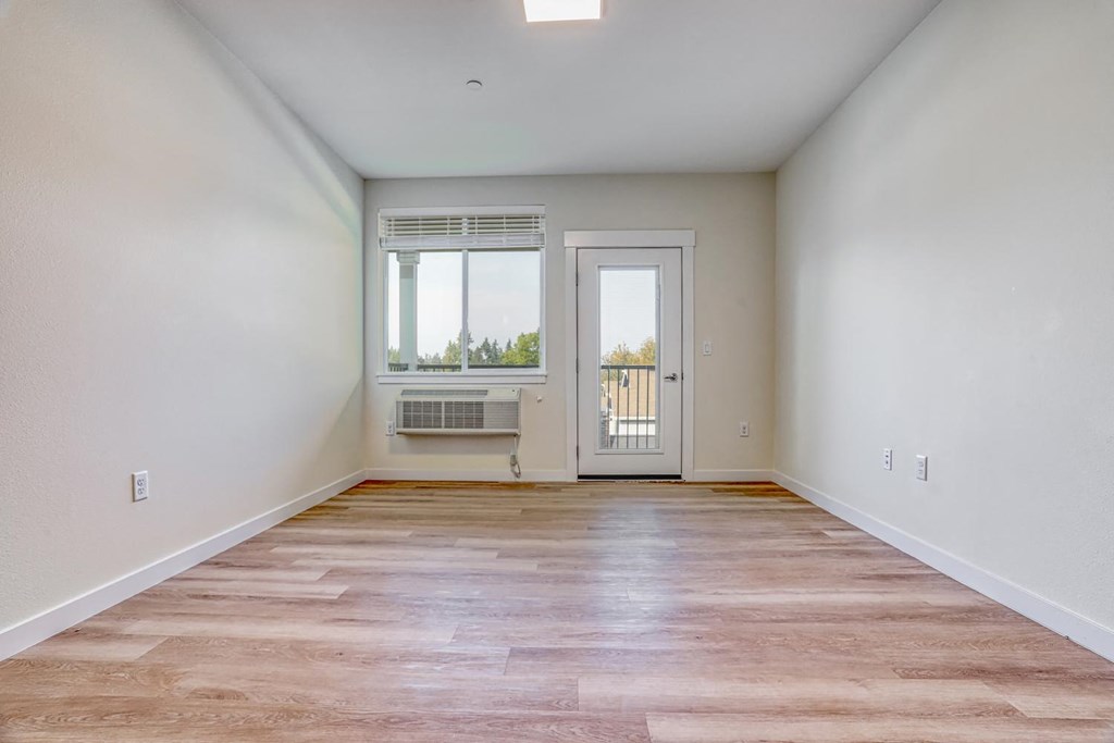 a bedroom with hardwood floors and white walls