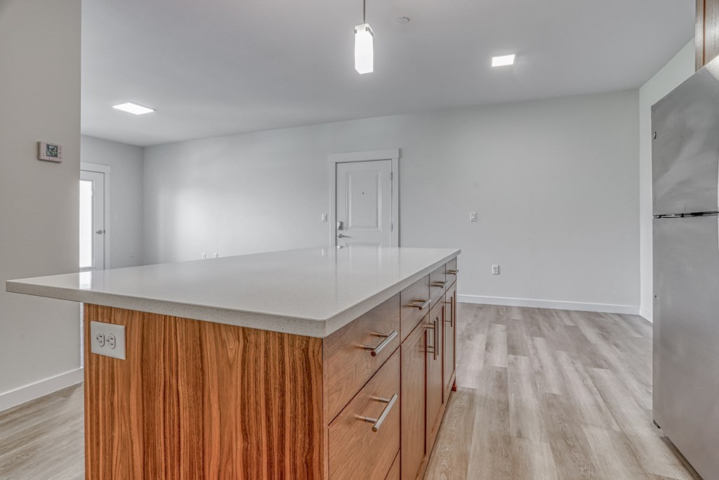 a kitchen with white countertops and wooden cabinets
