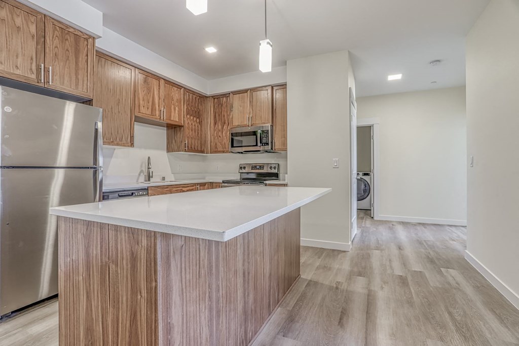 a kitchen with white countertops and wooden cabinets