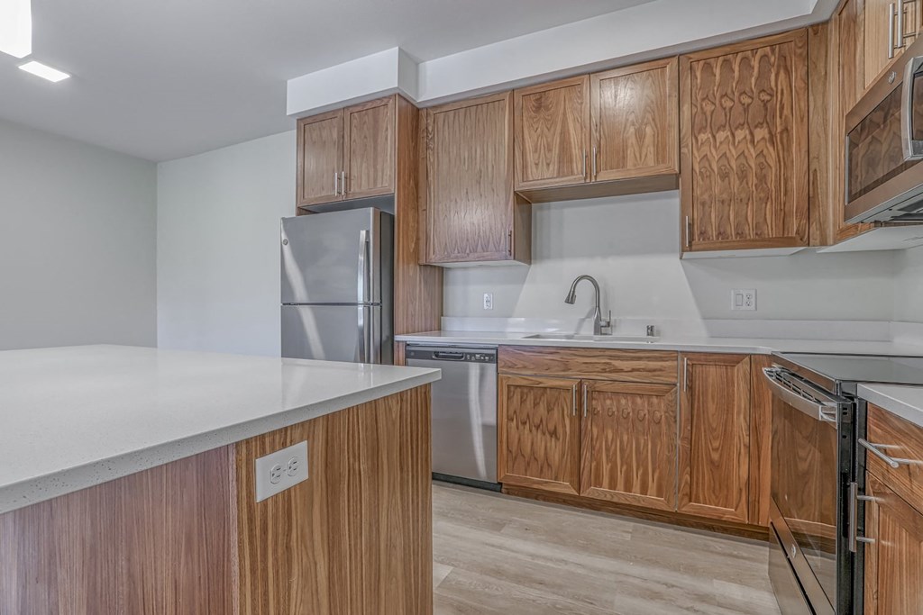 a kitchen with white countertops and wooden cabinets