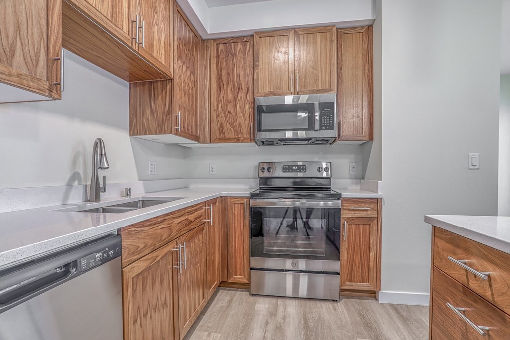 a kitchen with wooden cabinets and stainless steel appliances